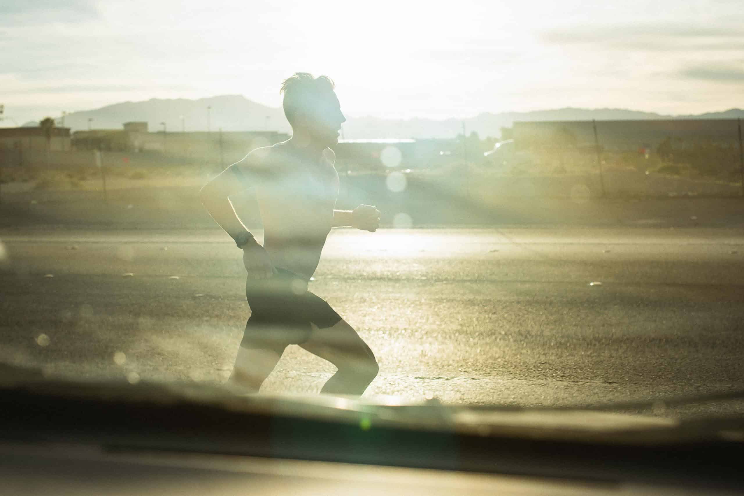 Sillhouette of a runner in the setting sun.