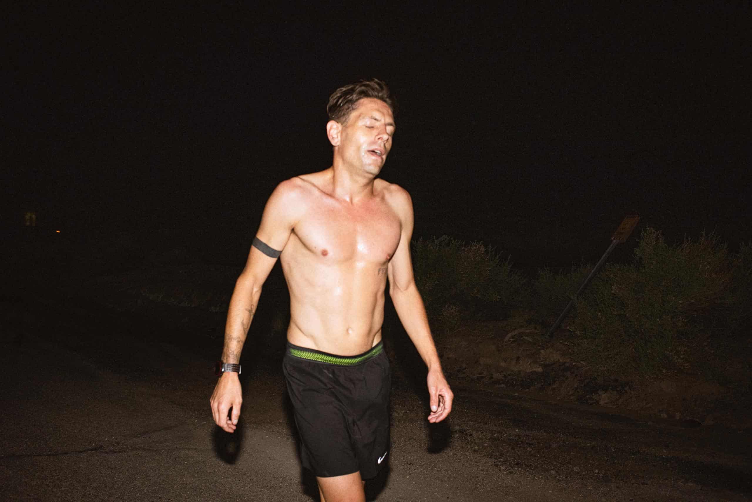 Nils Arend, a tired runner without his shirt on in the dark