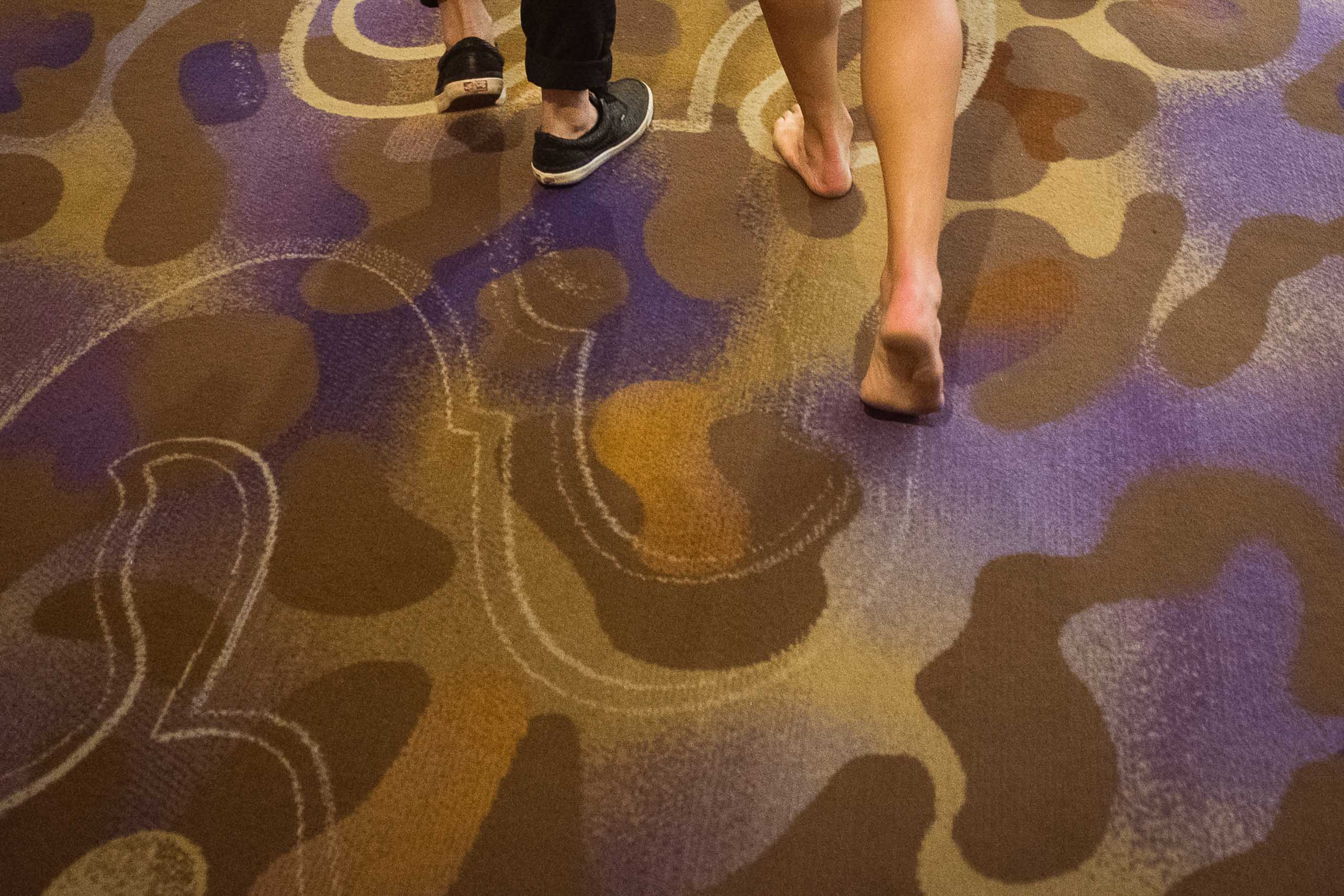 Two people walking along the Las Vegas floor, one without shoes